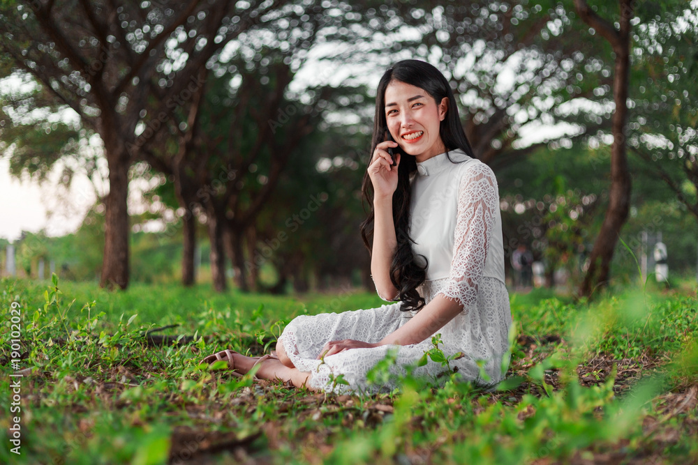 smiling woman talking on mobile phone in park smiling woman talking on mobile phone in park