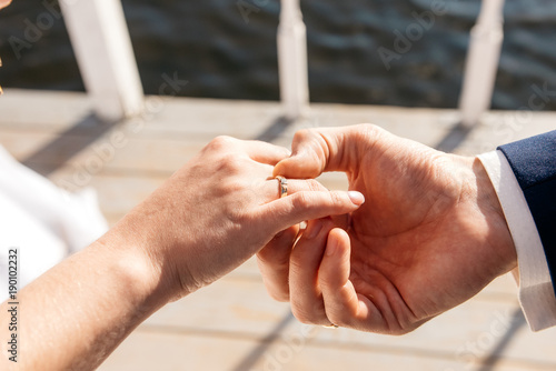 Fotografija The groom dresses the bride's engagement ring on the finger