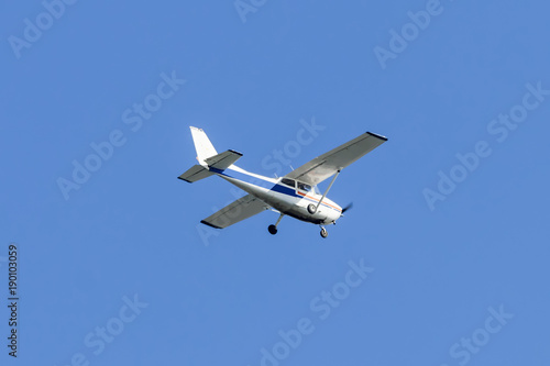 Single engined light aircraft flying over a clear blue sky
