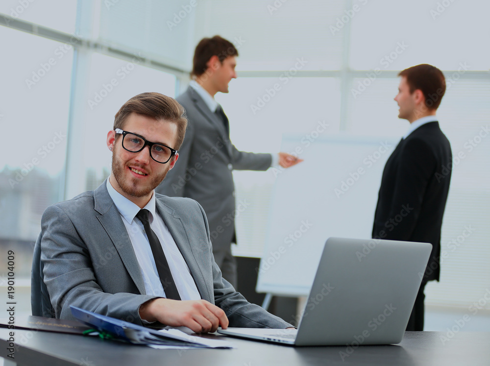 Portrait of a handsome young business man with people in background at office meeting. Portrait of a handsome young business man with people in background at office meeting.