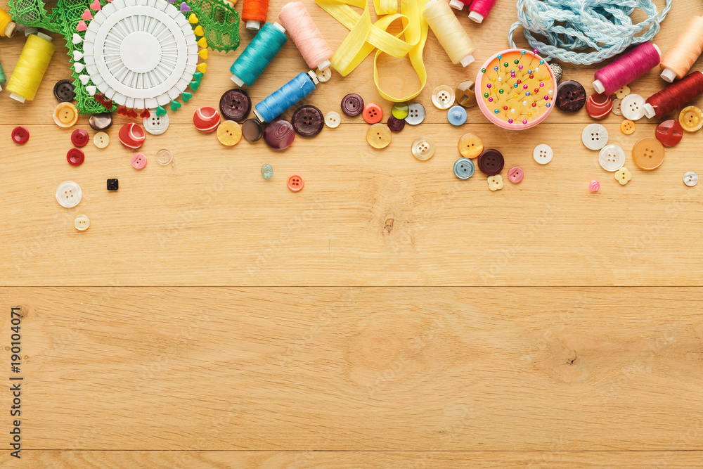 Collection of threads and buttons on wooden table background Collection of threads and buttons on wooden table background