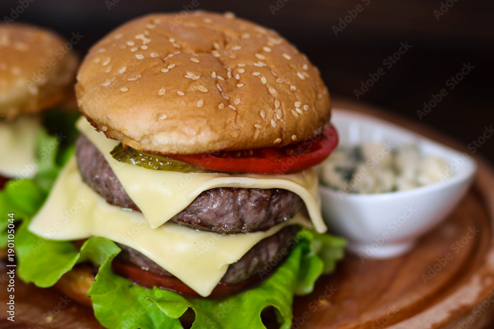 Homemade burger on wooden cutting board. Homemade burger on wooden cutting board.