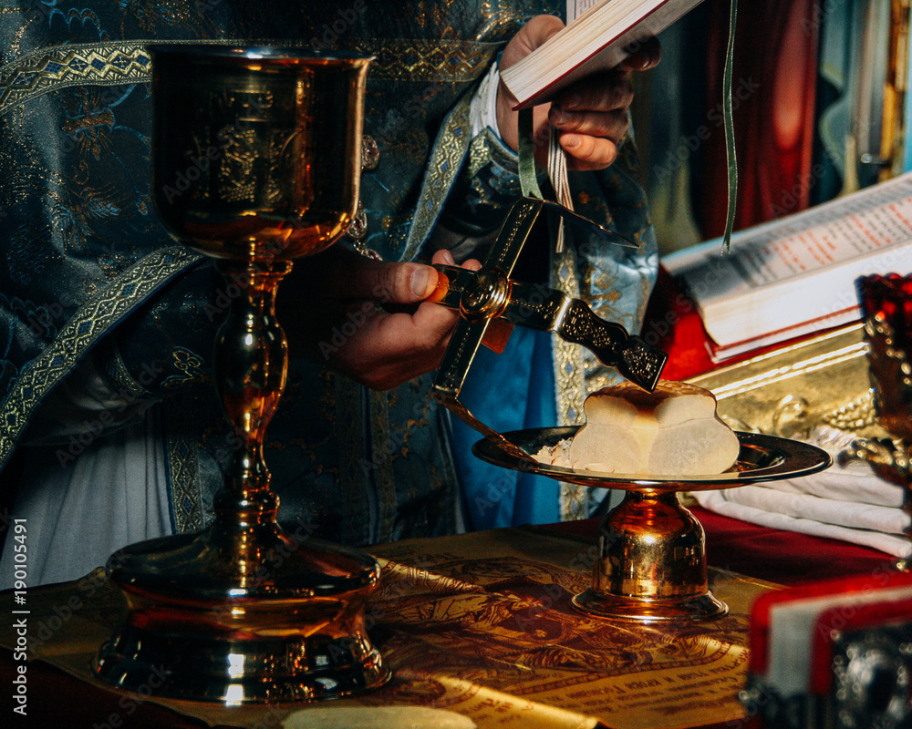 Naklejka premium Hands of priest and orthodox prosphora