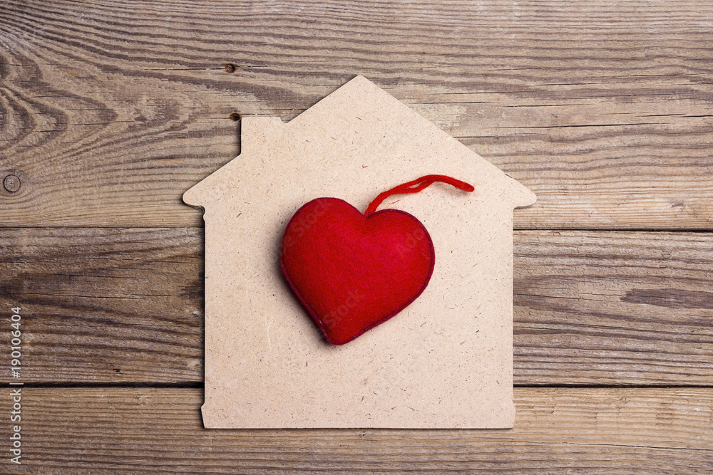 Home symbol with red heart on wooden background. Home symbol with red heart on wooden background.