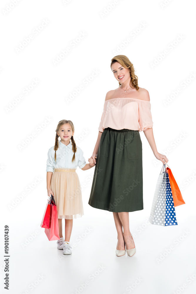 stylish mother and daughter with shopping bags holding hands isolated on white stylish mother and daughter with shopping bags holding hands isolated on white
