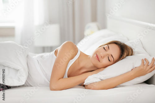 Young woman sleeping on white pillow in bed © Africa Studio