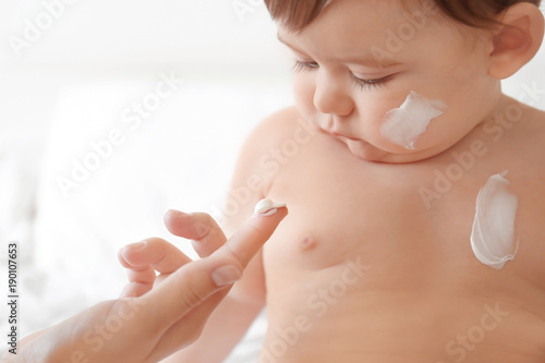 Woman applying body cream o...