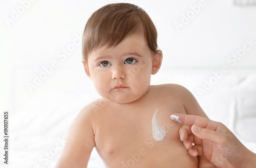 Woman applying body cream o...