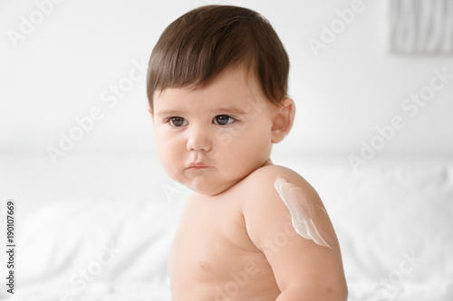 Cute baby with body cream o...