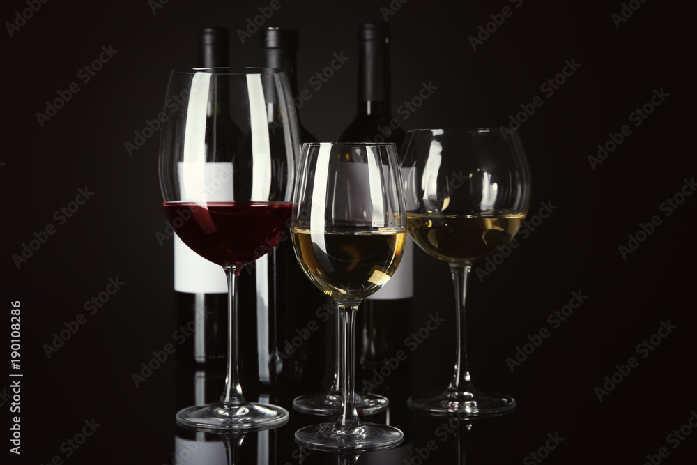 Glasses and bottles with different wine on black background Glasses and bottles with different wine on black background