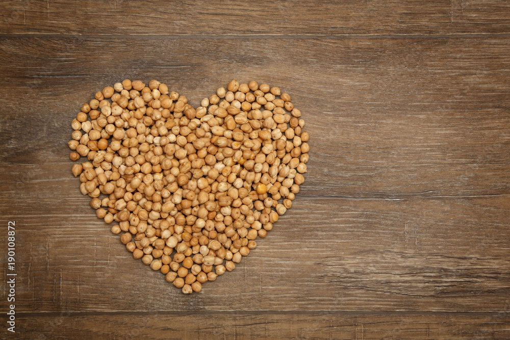 Heart of chickpeas on brown wooden table