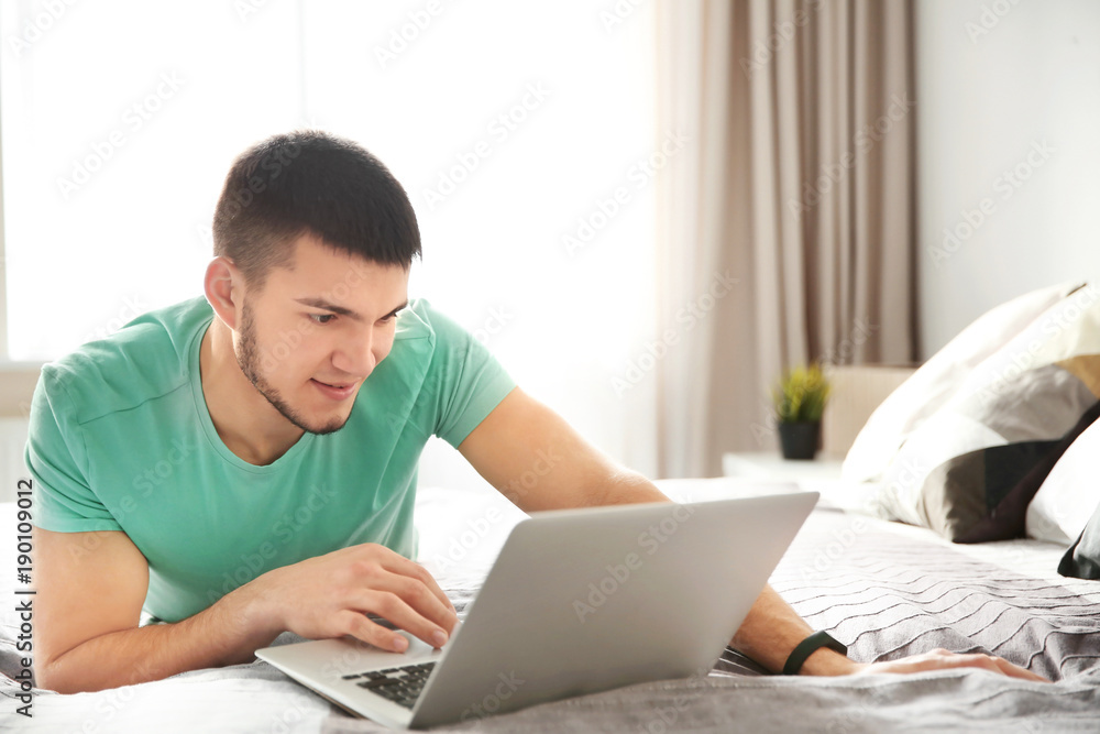 Young man using laptop at home Young man using laptop at home