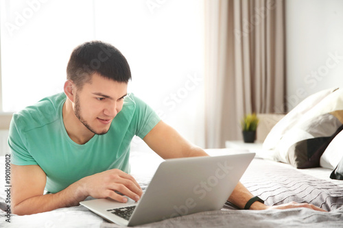 Young man using laptop at home