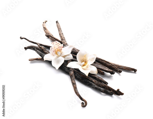 Vanilla sticks and flowers on white background