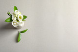 Beautiful white flowers in vase on grey background