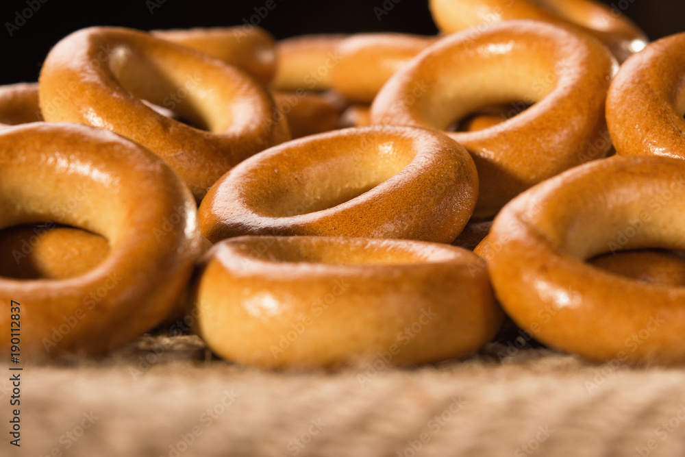 Small dry bagels on a wooden table, view from the side. Small dry bagels on a wooden table, view from the side.