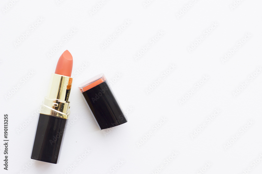 Make Up Beauty Concept. Matte coral lipstick in black tube on white background, top view, flat lay Make Up Beauty Concept. Matte coral lipstick in black tube on white background, top view, flat lay
