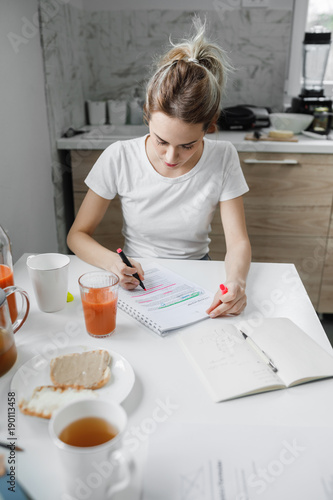 Pretty Caucasian young woman studying at home. photo