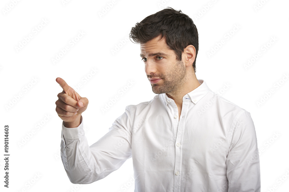 Portrait of smiling young businessman pointing something with his finger while standing against isolated white backgroun Portrait of smiling young businessman pointing something with his finger while standing against isolated white backgroun