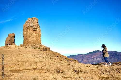 Woman hiking on trail to Roque Nublo - Gran Canaria - Tejeda - Blue sky over Canary Islands