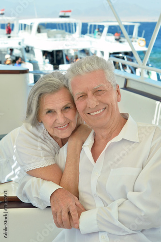 Smiling elderly couple resting on yacht