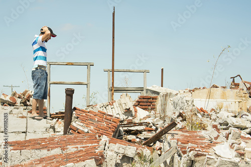 Man observing the destruction of his home. © Denise