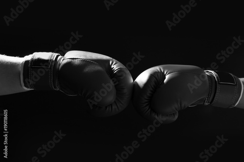 Confrontation of fighters with boxing gloves on black background © Africa Studio