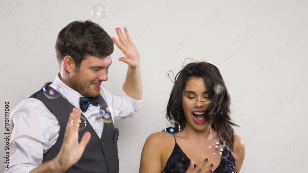 happy couple dancing in soap bubbles at party happy couple dancing in soap bubbles at party