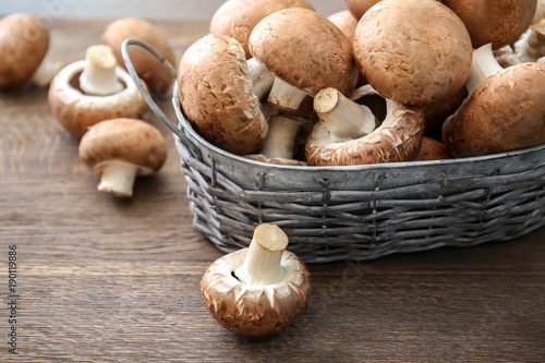 Basket with mushrooms on wooden table