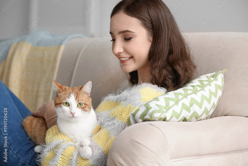 Beautiful young woman with cute cat on sofa at home Beautiful young woman with cute cat on sofa at home