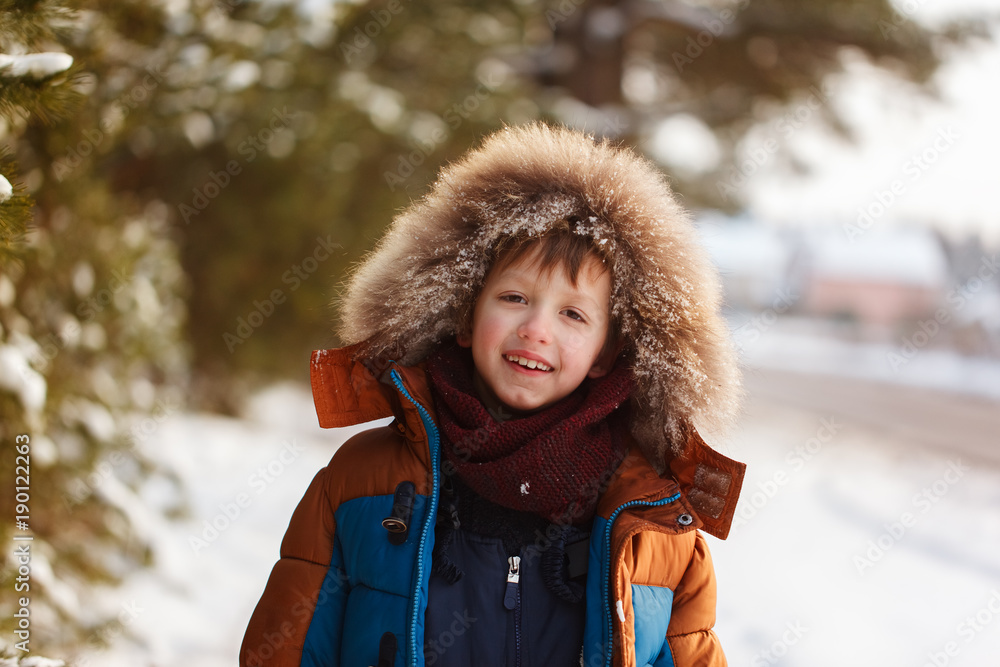 Happy child walking in a winter forest in sunny day Happy child walking in a winter forest in sunny day
