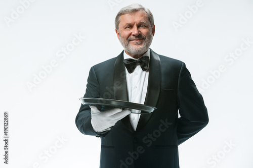 Senior waiter holding tray photo