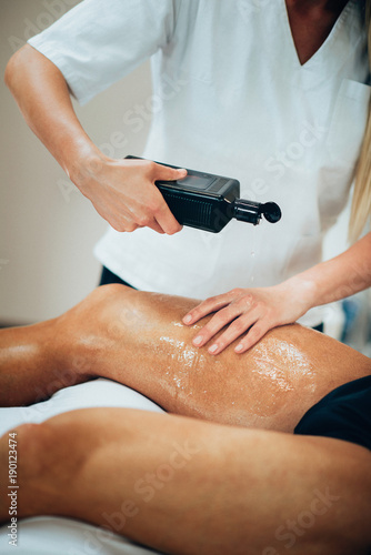 Sports massage. Therapist pouring massage oil