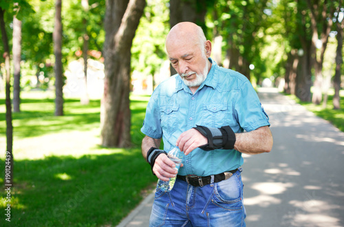 Fototapeta Naklejka Na Ścianę i Meble -  Senior man in casual wear with water bottle