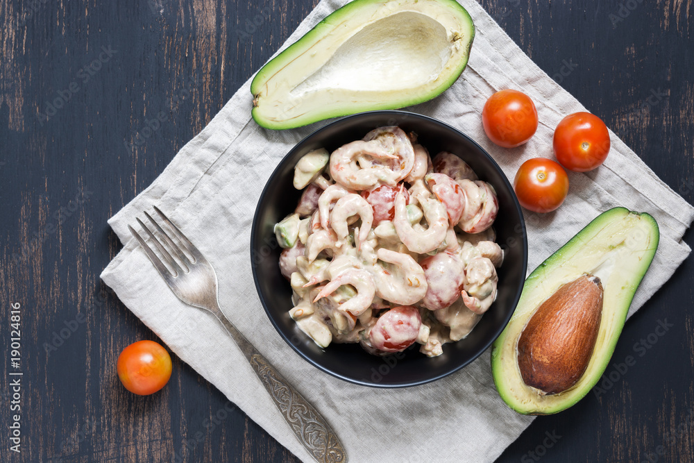Salad with avocado shrimp and tomato sauce served in a black bowl. Salad with avocado shrimp and tomato sauce served in a black bowl.