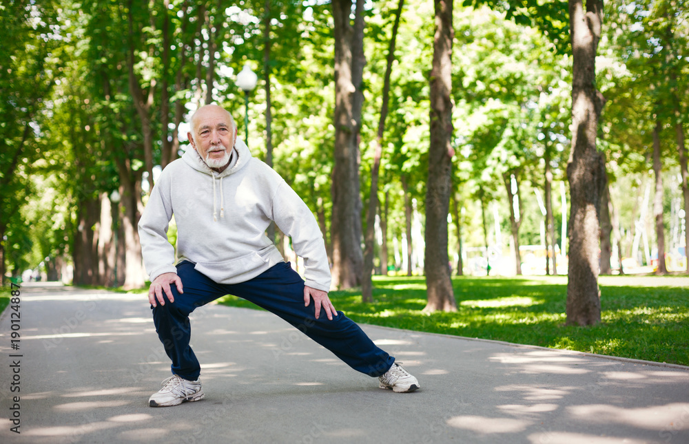 Elderly man running in green park, copy space Elderly man running in green park, copy space