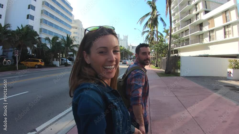 Couple of tourists walking in the streets of Miami South beach Couple of tourists walking in the streets of Miami South beach