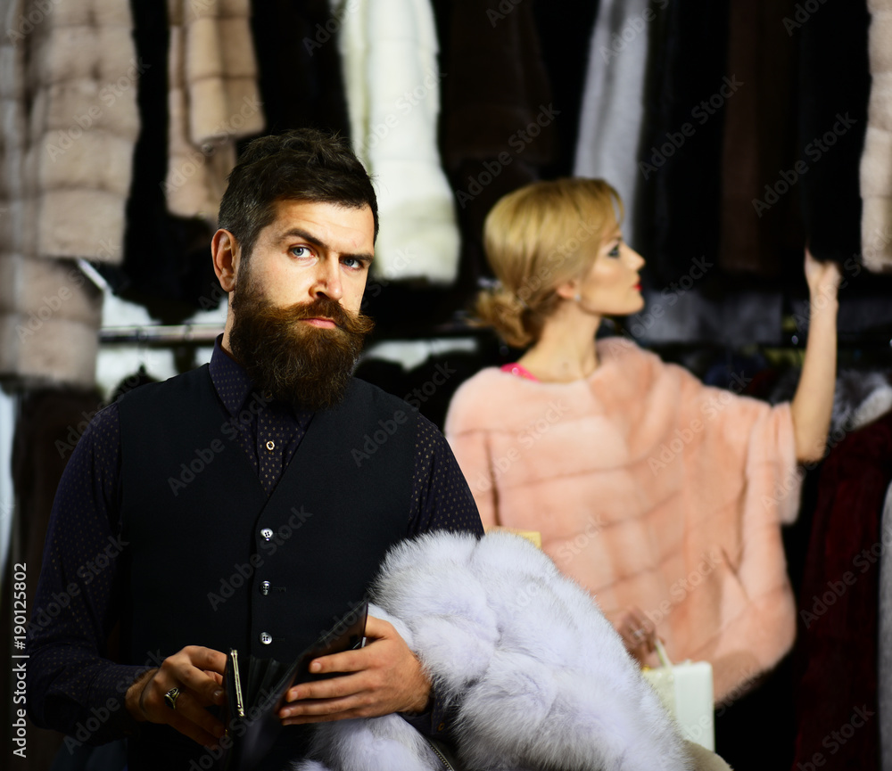 Couple in love tries expensive overcoats. Luxury and relationship Couple in love tries expensive overcoats. Luxury and relationship