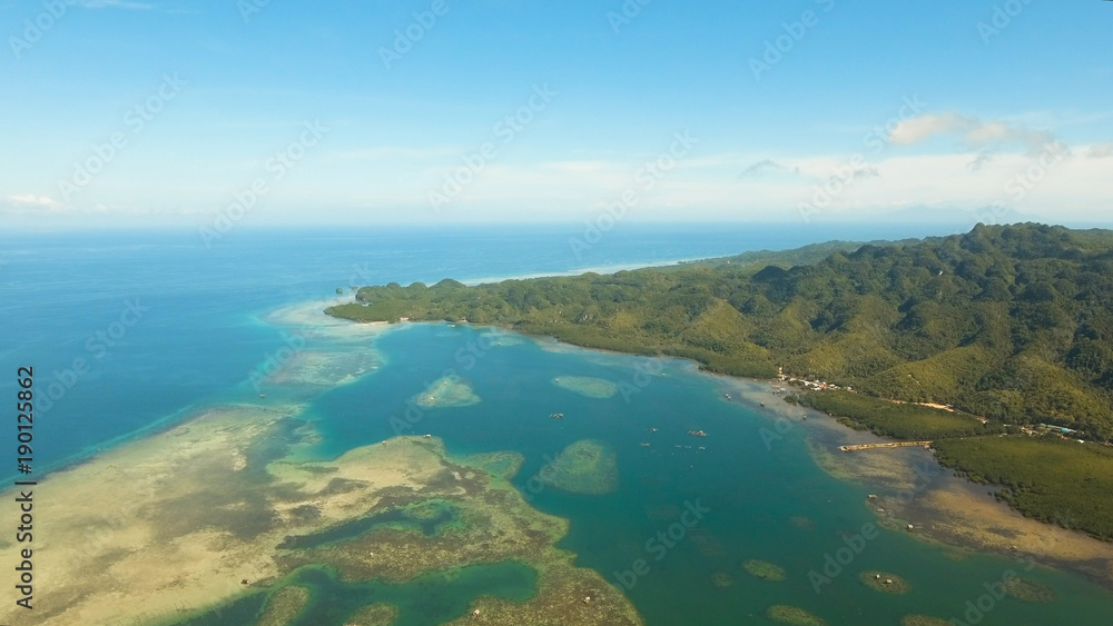 Aerial view: beach, tropical island, sea bay and lagoon, Bohol. Tropical landscape hill, clouds and mountains rocks with rainforest. Azure water of lagoon. Shore Landscape Bay. Aerial video.Seascape