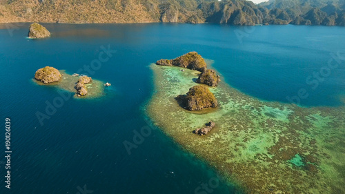 Aerial view: beach, tropical island, sea bay and lagoon, Palawan. Lagoon with blue, azure water in the middle of small islands and rocks. Busuanga. Seascape, tropical landscape. Philippines.