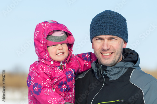 Happy father walking with pretty beautiful little girl in winter