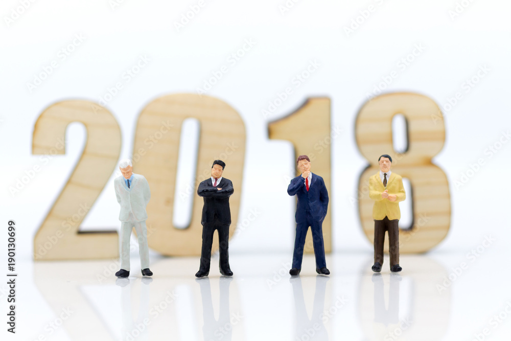 Miniature people: Businessman standing front of wood block 2018. Image use for business concept. Miniature people: Businessman standing front of wood block 2018. Image use for business concept.