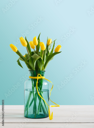 Yellow tulips bouquet on blue background