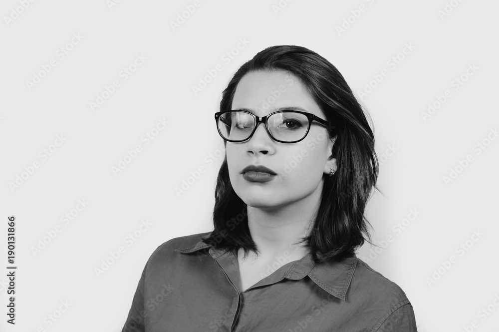 Portrait of young woman wearing glasses isolated on gray background with copy space
