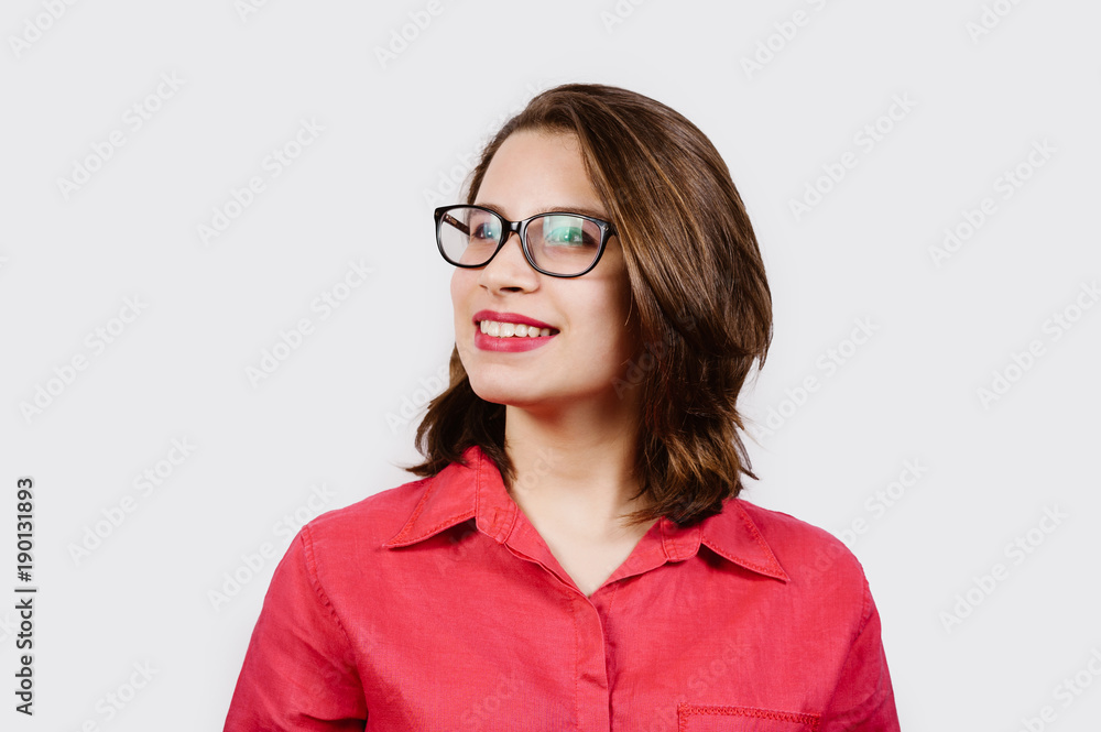 Portrait of a happy casual girl looking away at copy space and wearing eye glasses over white background