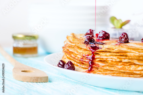 English-style pancakes with syrup on turquoise wooden table, traditional for Shrove Tuesday. Healthy breakfast concept. Close up.
