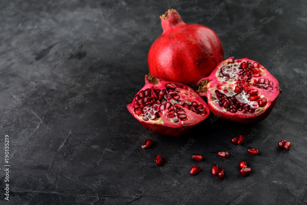 fresh sliced pomegranates on dark background fresh sliced pomegranates on dark background