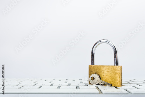 Background image of golden metal lock and key on keyboard photo