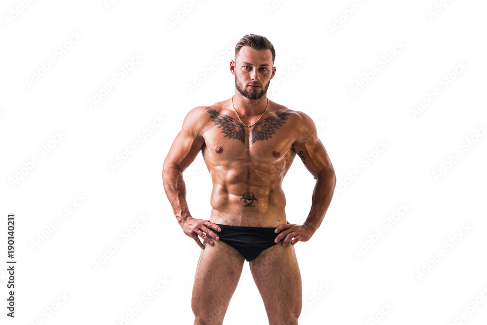 Handsome shirtless muscular man, standing, in studio shot, looking at camera, isolated on white