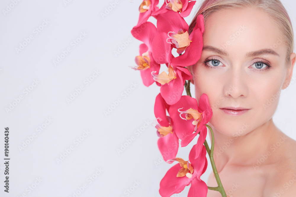 Young beauty woman with flower near face